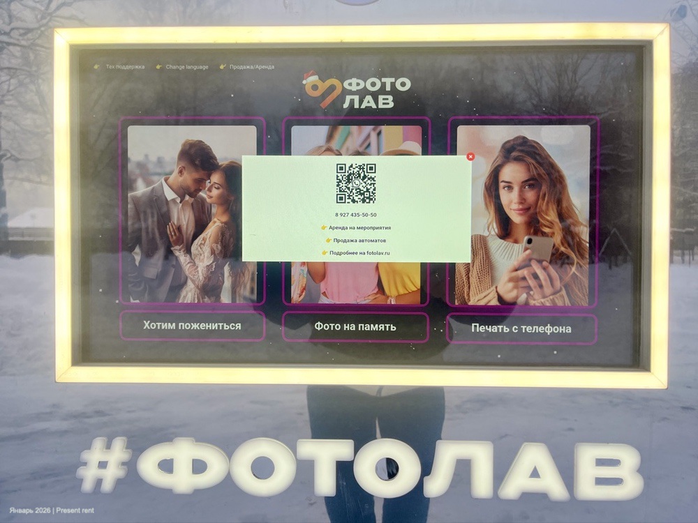 Вывеска с темой 'Фотолав', предлагающая услуги фотографирования, печати и аренды. На экране QR-код и контактный номер телефона для связи.