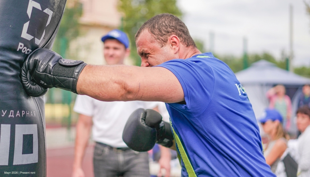Боксер, наносящий удар по боксерской груше на тренировке.